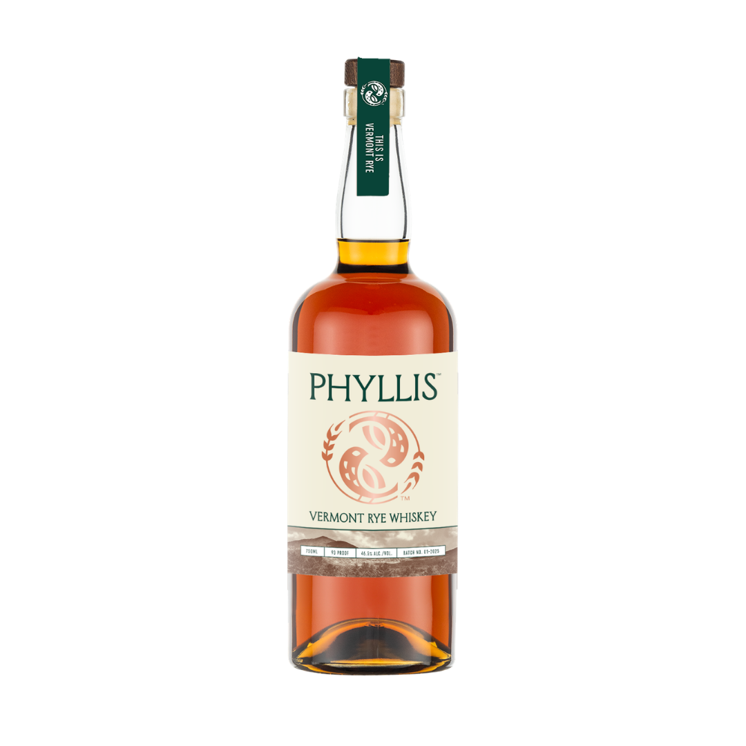 A bottle of Phyllis Vermont Rye Whiskey on a plain white background. The bottle is filled with amber-colored whiskey and features a cream-colored label with green text, a copper logo, topped with a dark green neck label.